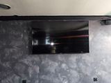 a black leather couch sitting in front of a flat screen tv