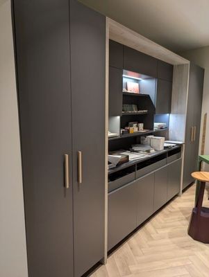 une cuisine équipée d'un plan de travail, de placards et d'un tabouret