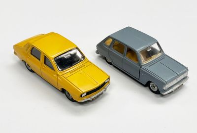 deux voitures jouets assises l'une à côté de l'autre sur une surface blanche