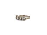 a close up of a ring with three diamonds on a white background