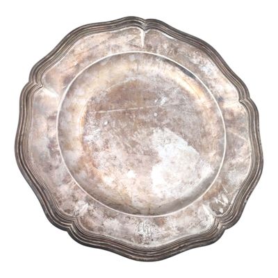 une assiette en argent posée sur une surface blanche