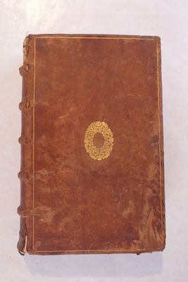 un livre marron orné d'un cercle doré