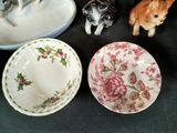 three bowls and a bowl with a dog figurine next to them
