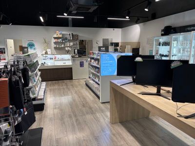 une photo d'un magasin d'informatique avec deux écrans posés sur le comptoir