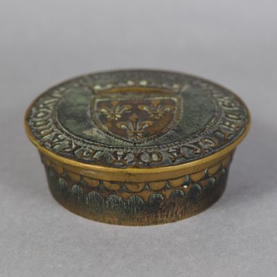 an antique brass box with a crest on the lid