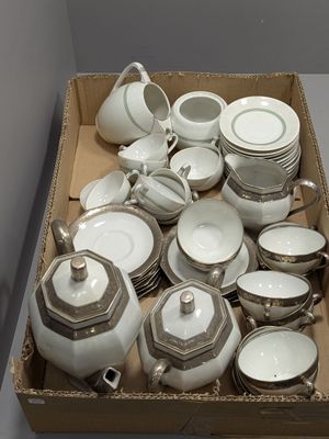 une boîte remplie d'assiettes et de tasses blanches et argentées