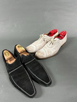 two pairs of men ' s shoes are lined up on a gray surface