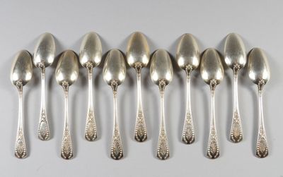 six cuillères en argent sont alignées sur une table