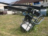 a crane that is sitting in the grass in front of a building