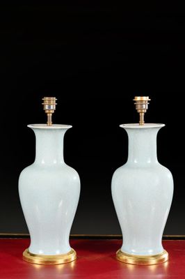pair of white and gold vases sitting on a red surface