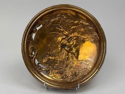 une image représentant une assiette en or sur laquelle figurent un homme et une femme