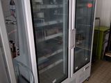 two refrigerators that are sitting in a room