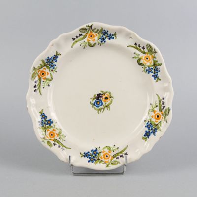 an image of a white plate with blue and yellow flowers
