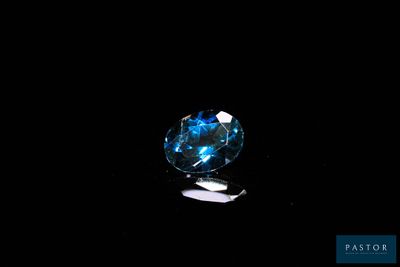 gros plan d'un diamant bleu sur une surface noire