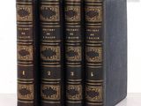 quatre livres sont alignés sur une surface blanche