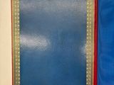 an open blue book with gold trim and a red cover