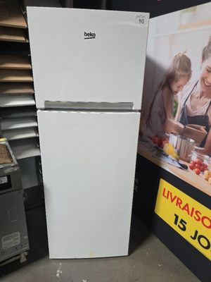 un réfrigérateur blanc dans un magasin, avec une photo accrochée au mur derrière lui