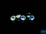 a group of three different colored gems sitting on top of a black surface