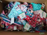 a cardboard box full of baby clothes and other items