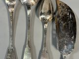four spoons, a fork, and a spoon on a table