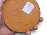 a person holding a brown plate with a sticker on it