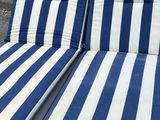 pair of blue and white striped outdoor chaise loungers