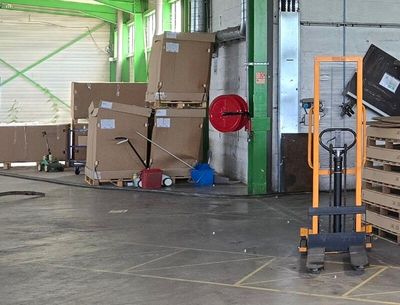 many boxes and pallets in a warehouse with a fork lifter