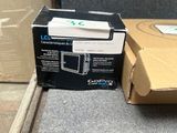 une boîte de télécommandes Wii posée par terre à côté d'une boîte de manettes Wii
