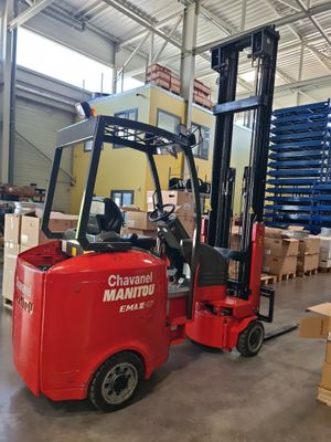a red forklift in a warehouse with boxes on the floor