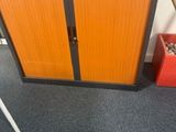 une armoire orange sur laquelle est posée une batte de baseball