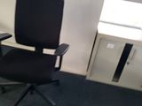 a black office chair sitting in a corner of a room