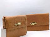 two tan leather wallets with a gold clasp on each of them