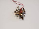 a gold snowflake ornament hanging from a red string