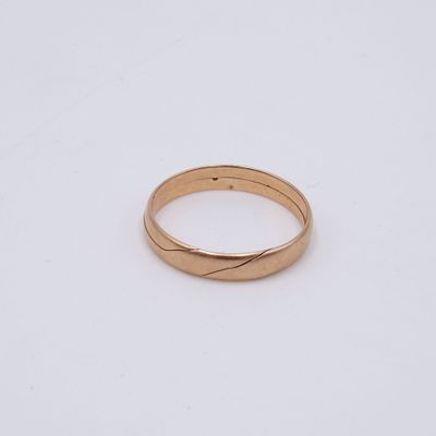 gros plan d'une bague en or sur une surface blanche