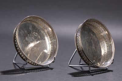 paire de miroirs anciens plaqués argent sur pied, sur fond gris