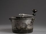 an old metal pot with a wooden handle on a gray surface