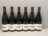 six bouteilles de vin rouge alignées sur une table
