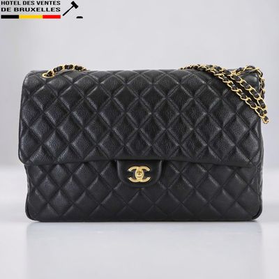 un sac à bandoulière Chanel en cuir matelassé noir, avec des finitions dorées