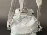 the back view of a backpack with a white bag attached to it