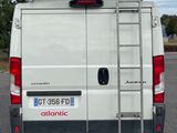 a white van parked in a parking lot with a ladder on the back of the van