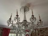 a chandelier in the middle of a room with red curtains