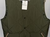 an image of a vest hanging on a hanger in a room