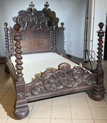 un lit en bois avec une tête et un pied de lit sculptés