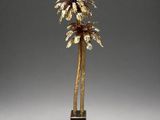 a gold palm tree on a black base with a white background