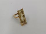 Gros plan sur une bague en or ornée d'une pierre verte