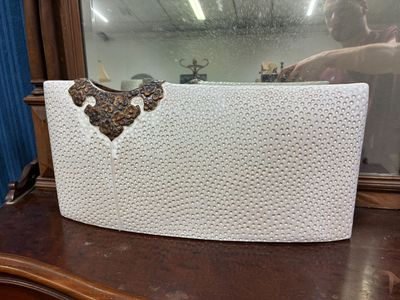 un sac à main blanc posé sur une commode