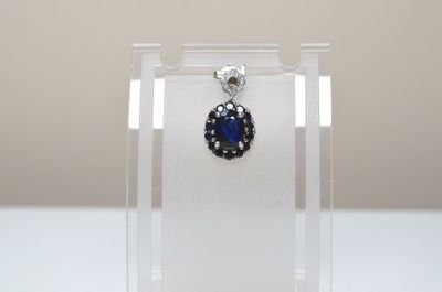 boucles d'oreilles en saphir bleu et diamants exposées dans une vitrine en acrylique transparent