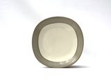 a white plate with a gray rim sitting on a white surface