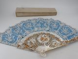 a blue and white hand fan and a ruler on a table