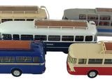 quatre petits bus qui sont rangés les uns à côté des autres